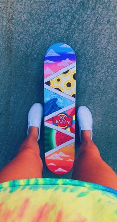 a person standing next to a skateboard on top of a cement floor with their feet up