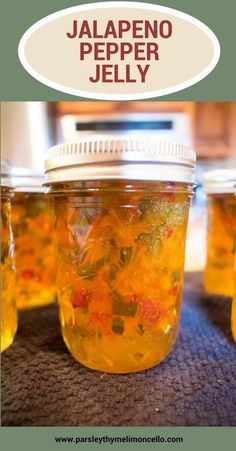 jars filled with jelly sitting on top of a table next to a microwave oven and the words jalapeno pepper jelly