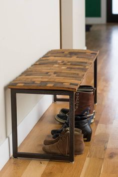 a pair of shoes sitting on top of a wooden bench next to a white wall