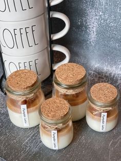 four jars filled with coffee sitting on top of a table