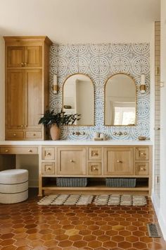 a bathroom with wooden cabinets and tile flooring, along with two mirrors on the wall