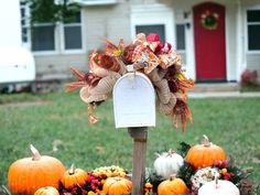 a mailbox decorated with fall decorations in front of a house