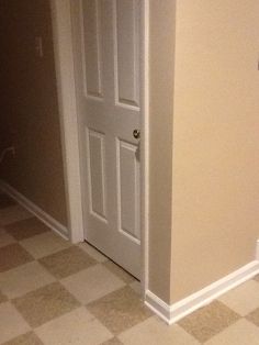 an open door in a room with checkered flooring on the floor and walls