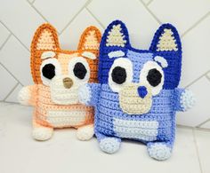 two crocheted stuffed animals sitting next to each other on a white counter top