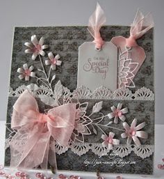 a greeting card with pink bows and lace on it's side, next to some flowers