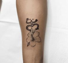 a woman's arm with a flower tattoo on it, and an omen symbol in the middle