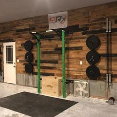 an indoor gym with wooden walls and green bars