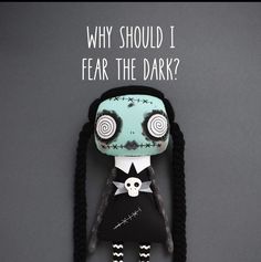 a doll with long black hair and a skull on it's head that says, why should i fear the dark?