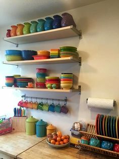 the shelves are full of colorful dishes and bowls on them, along with other kitchen items