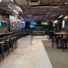 an empty sports bar with tables and chairs