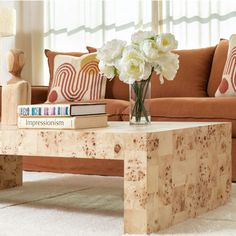 a coffee table with books and flowers on it