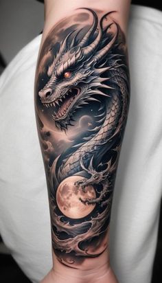 a man's arm with a dragon and moon tattoo on the side of his arm