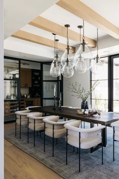 a dining room table with chairs and chandelier hanging from it's ceiling