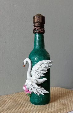 a green bottle with a white swan on it