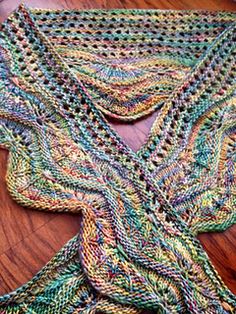 a crocheted shawl sitting on top of a wooden table