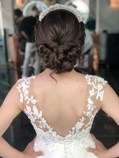 the back of a woman's wedding dress, with her hands on her hips