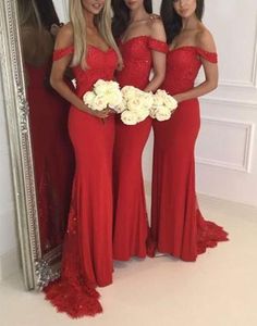 three women in red dresses standing next to each other and one holding a white bouquet