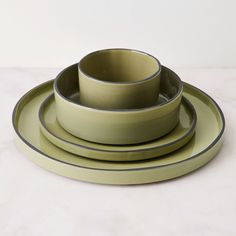 three plates and two bowls on a table