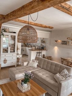 a living room filled with furniture and wooden beams