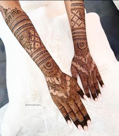 two hands with henna tattoos on them