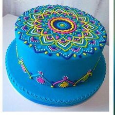 there is a blue cake with colorful decorations on it's top and bottom layer