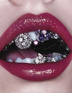 a woman's lips are adorned with jewels