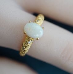 Embrace timeless elegance with our Vintage-Look Classic Style White Opal Ring. This stunning piece exudes sophistication, featuring a captivating white opal set in a vintage-inspired design. The ring effortlessly blends classic charm with contemporary style, making it the perfect accessory for any occasion. These opal stones are untreated and unprocessed, ensuring their genuine nature. All orders include tracking for your assurance. If you have any uncertainties regarding your order, please feel Elegant Hallmarked Opal Ring, Elegant Gold Opal Cabochon Ring, Elegant Gold Opal Ring, Elegant Gold Oval Opal Ring, Elegant Yellow Gold Opal Rings, Gold Oval Cabochon Opal Promise Ring, Elegant Opal Cabochon Promise Ring, Elegant Opal Promise Ring With Cabochon, White Opal Ring