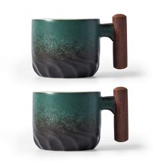 two green coffee mugs with wooden handles on each one and the other is made out of ceramic