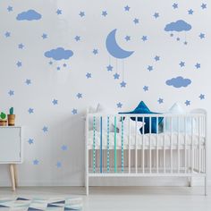 a baby's room with stars and moon decals on the wall, along with a crib