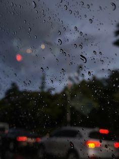 rain drops on the window as cars drive by