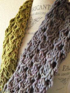 two knitted scarves sitting on top of each other