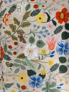 the fabric has many different flowers and butterflies on it