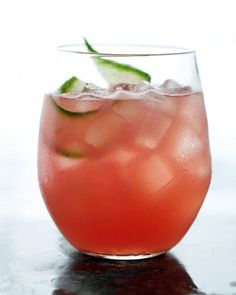 a close up of a drink in a glass with ice and garnishes