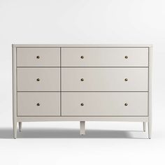 a white dresser with six drawers and two handles on one side, in front of a plain background