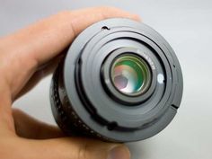 a person holding a camera lens in their hand