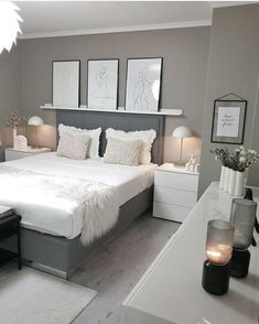 a bed room with a neatly made bed and some pictures on the wall above it