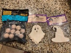 three bags of halloween decorations are on the counter next to each other, including one ghost and two white eggs