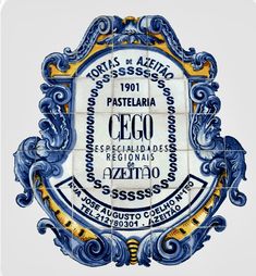 an ornate blue and yellow tile plaque with words in spanish on the bottom, below it