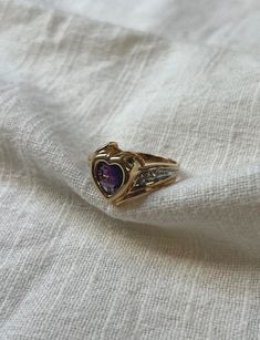 Beautiful vintage ring ca. 1990s. Ten-carat yellow gold cradles a sweet, heart-shaped genuine amethyst, accented by four genuine diamonds.  10 karat yellow gold Heart-shaped checkerboard carved amethyst Center amethyst is approximately 6.8 x 7 mm (measured in mounting)  Four round accent diamonds Total diamond weight ~ approximately 0.04 carat Ring size 6.5 U.S.  Total weight ~ 5.16 grams Hallmark stamp reads "10K PMG" This vintage piece is in unworn, like-new condition. All pieces are thoroughl Beautiful Rings Vintage, Diamond Heart Ring, Sweet Heart, Vintage Ring, Gold Heart, Diamond Heart, Heart Of Gold, Chicago Il, Rings Statement