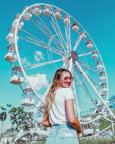 a woman standing in front of a ferris wheel