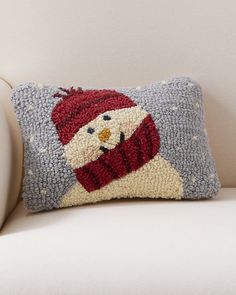 a pillow with a snowman on it sitting on a couch