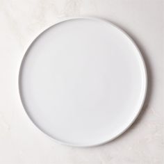 an empty white plate sitting on top of a table