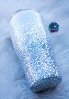 a blue and white glittered case sitting on top of a fur covered floor next to a button