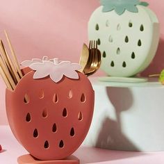 a strawberry shaped utensil holder sitting on top of a table