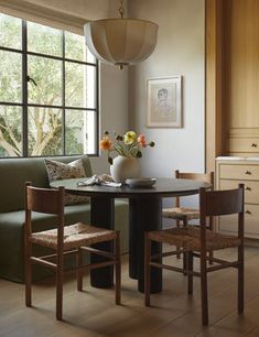 a living room filled with furniture next to a kitchen table and chairs in front of a window