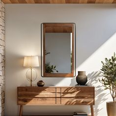 a wooden dresser sitting next to a mirror on top of a wall near a potted plant