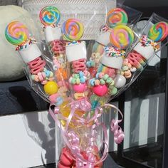 a vase filled with candy and lollipops on top of a table