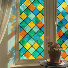 a potted plant sitting in front of a stained glass window