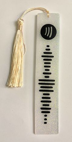 a bookmark with a tassel hanging from it's side on a white surface