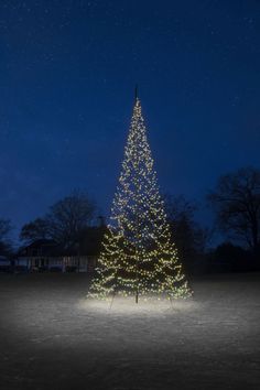 a lit up christmas tree in the middle of a field